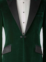Load image into Gallery viewer, A green velvet dinner jacket designed for black-tie events, featuring a single-breasted one-button closure with a link button, silk peak lapels, and elegant paisley lining. Styled with a classic white dinner shirt with a Marcella front and dress studs, adding timeless sophistication to the ensemble.