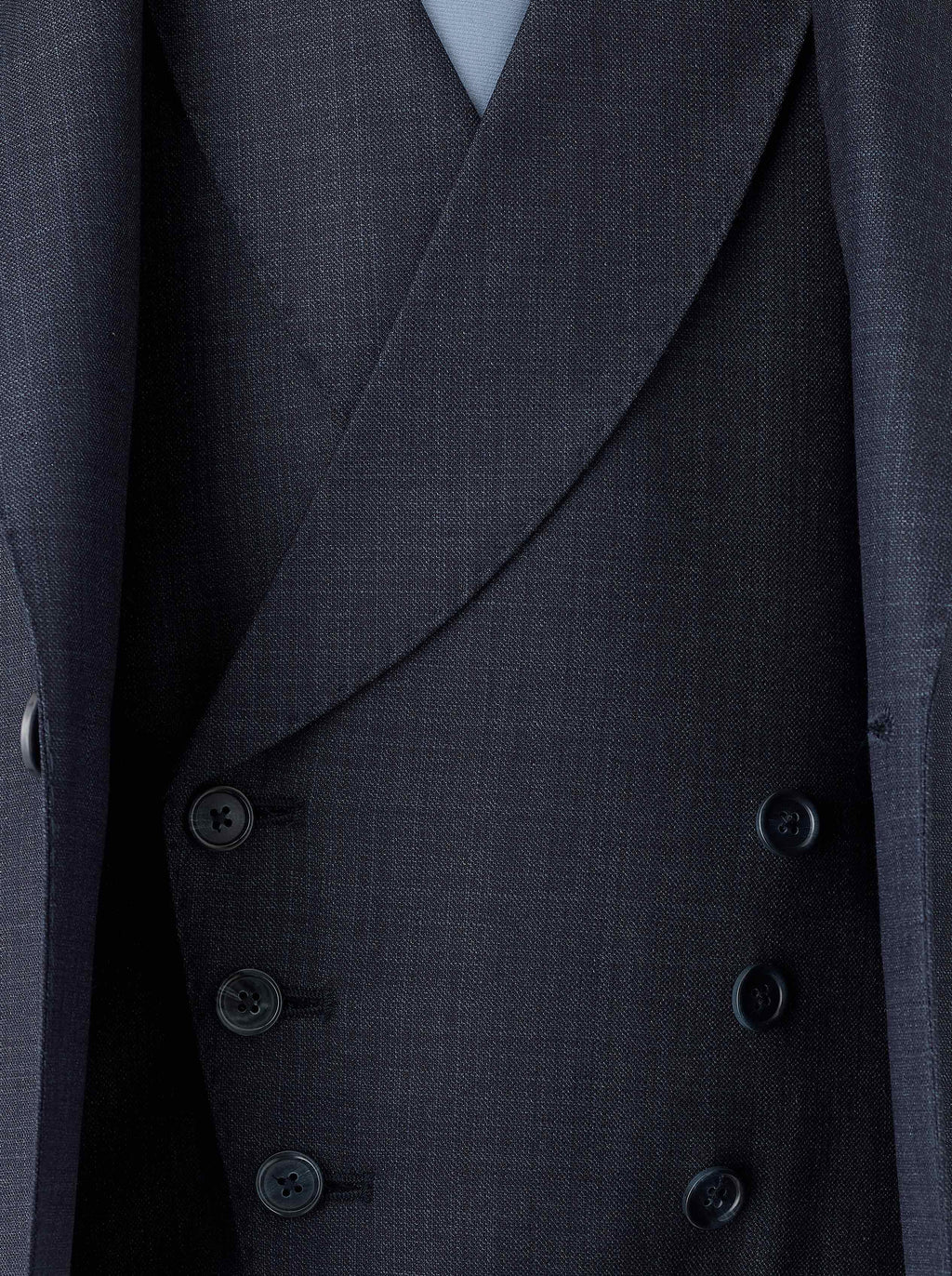 A double-breasted blue waistcoat crafted from Super 130s Italian wool, featuring a 3x3 button design with grey horn buttons, welt pockets, and a straight bottom. The navy lining matches the jacket, while the back lining includes a belt and buckle for an adjustable fit.