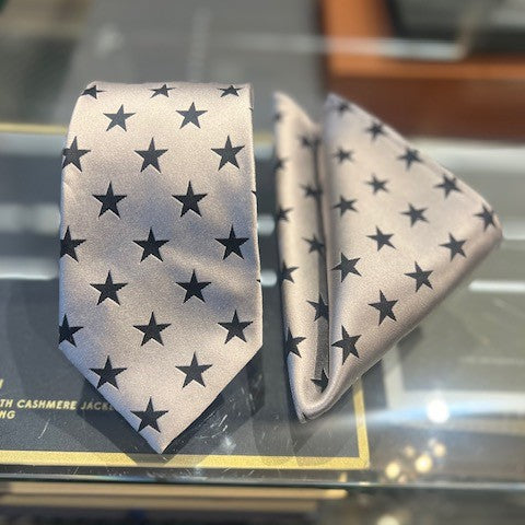 Star-patterned tie and pocket square on a glass surface