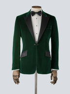 A green velvet dinner jacket designed for black-tie events, featuring a single-breasted one-button closure with a link button, silk peak lapels, and elegant paisley lining. Details include silk-covered buttons, double vents, a handkerchief pocket, and slanted silk pocket flaps that can be tucked in for a jetted look.